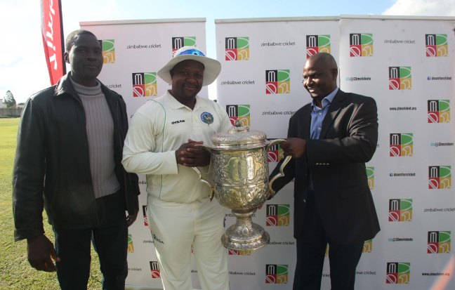 Zimbabwe Cricket chairman Tavengwa Mukuhlani hands the Logan Cup to Manicaland Mountaineers captain Tino Mawoyo.jpg